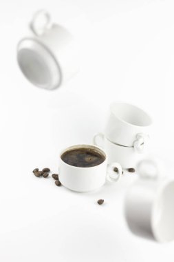 Kahve fincanları beyaz bir arka planda beyaz bir masada asılı duruyor.