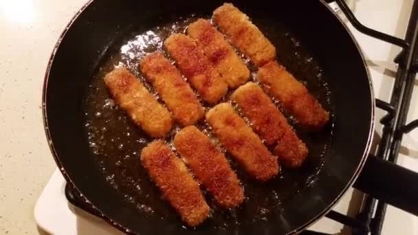 Bâtonnets de poisson dans une casserole — Video