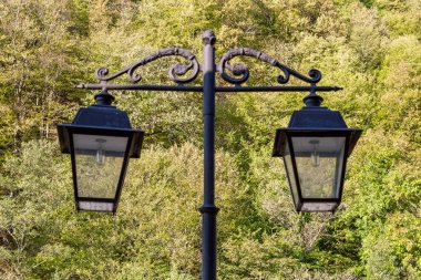 Halka açık bir parkta antika siyah bir fener.