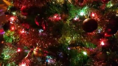 Parlak oyuncakları ve yanıp sönen renkli çelengi olan Noel ağacı.