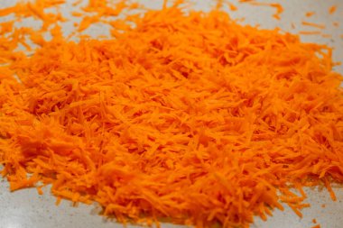 Çeşitli sağlıklı yemekler için turuncu dokulu taze rendelenmiş havuç yüzeyi.