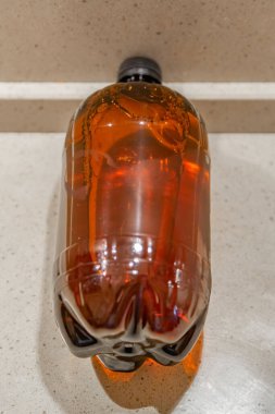 Büyük kahverengi plastik bir şişede taze bira.