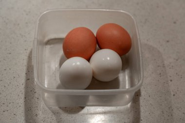 Gri arka planda salata için dört tavuk yumurtası haşlandı.