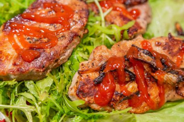 İştah açıcı bir parça iyi pişmiş et ve taze yeşil marul yaprakları.