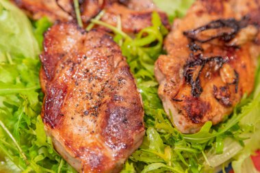 İştah açıcı bir parça iyi pişmiş et ve taze yeşil marul yaprakları.