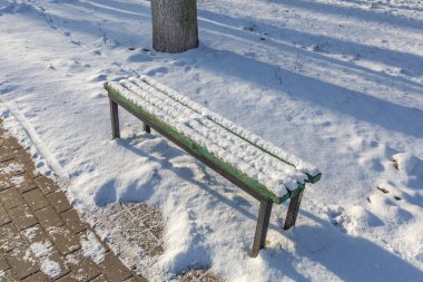Bir kış günü tatil köyünde turistler için dinlenme bankı.