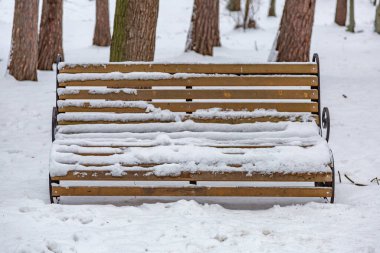 Bir kış günü tatil köyünde turistler için dinlenme bankı.