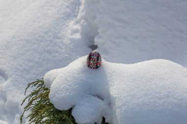 Beyaz kış karında boyanmış Paskalya yumurtası