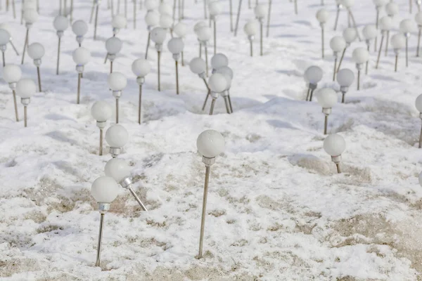 Kirli eriyen kar üzerinde güneş enerjisiyle çalışan çevre dostu ampuller.
