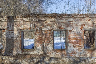 Gündüz vakti terk edilmiş eski bir taş binanın yıkılmış cephesinin bir parçası.