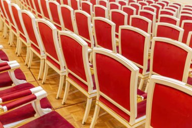 Tiyatro salonunda gösteriler için kırmızı kadife kaplı rahat tahta koltuklar. Konferans salonunun bir parçası.