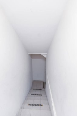 Beyaz duvarlar ve merdivenlerin taş basamakları evin bodrumuna iniyor.