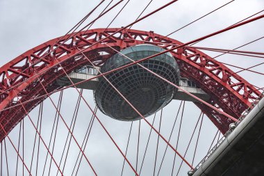 Moskova, Rusya - 8 Mayıs 2021: Zhivopisny Köprüsü. Bulutlu havada Moskva Nehri boyunca parlak kırmızı bir kablo yapısı. 2007 'de açıldı.