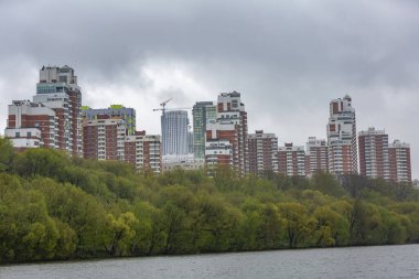 Moskova, Rusya - 8 Mayıs 2021: Bulutlu bir günde Moskva Nehri kıyısındaki konut binaları. Şehir yenileme programına göre konut inşaatı