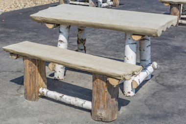 Boş bir bank ve doğal huş ağacından yapılmış bir masa.