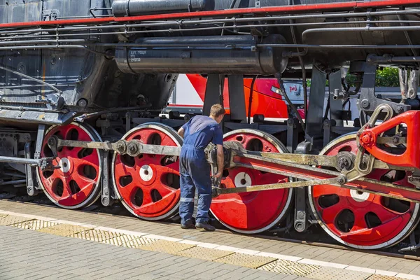 2021年7月11日 俄罗斯莫斯科 工人在里兹斯基车站的铁路站台上检查一辆黑色复古蒸汽机车 — 图库照片