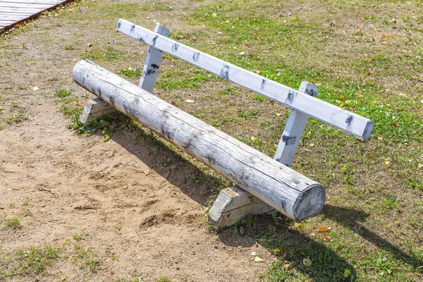 Yazın bir şehir parkında ahşaptan yapılmış bir bank.