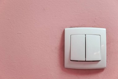 Odanın kabataslak boyalı duvarında iki düğmeli iç plastik düğme.