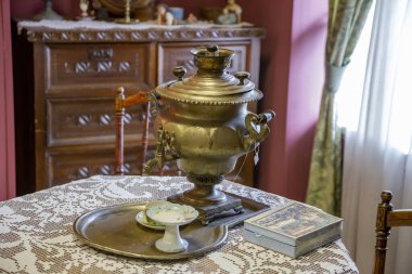 Solnechnogorsk, Rusya - 24 Temmuz 2021: Kaynar su ve çay yapmak için bir cihaz. Ahşap bir masada geleneksel Rus semaveri. Seyahat Sarayı Müzesi