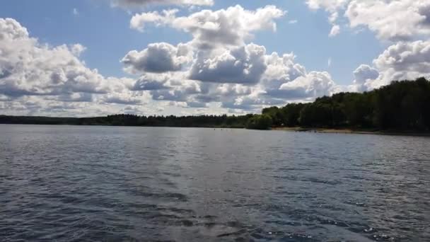 摩托艇沿着风景如画的塞涅兹湖的波浪航行 天空线 岸上绿树 晴天多云的蓝天 俄罗斯 莫斯科地区 — 图库视频影像