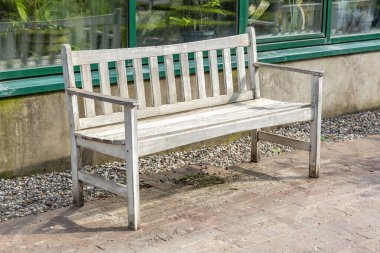 Yazın bir şehir parkında ahşaptan yapılmış bir bank.