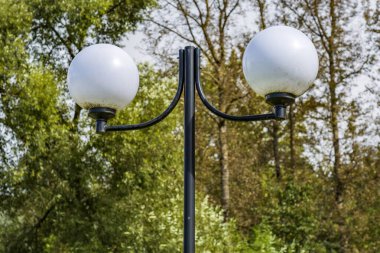 Gündüz vakti halka açık bir parkta antika demir fener.