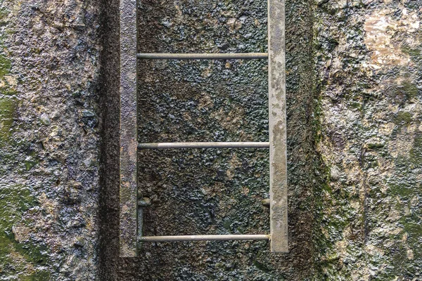 風化したコンクリート壁を背景に錆びた鉄筋で作られた金属製の階段 — ストック写真