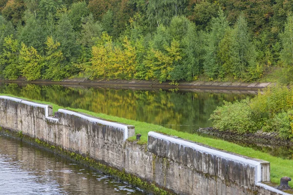 Scenic river landscape with green trees in early autumn