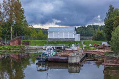 Sakin bir nehrin kıyısındaki tekneler ve küçük gemiler için yıpranmış rıhtım