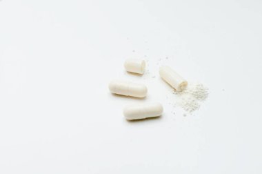 Beyaz arkaplanda beyaz toz bulunan beyaz haplar.