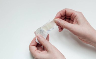 Disposable medical patch with hands on a white background