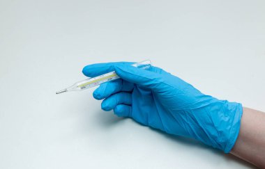 hand in a medical protective glove with a mercury thermometer on a white background