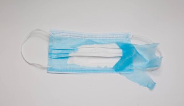 Beyaz arka planda iki katmanlı tıbbi koruyucu maske.