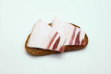 Beyaz arka planda çavdar ekmeğine iki dilim pastırmalı sandviç.