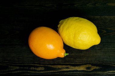 Koyu ahşap arka planda iki farklı limon..