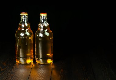 Koyu ahşap arka planda iki şişe light bira.