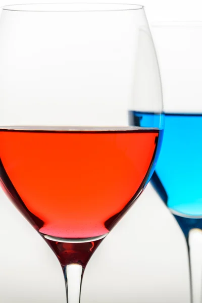 Two glasses with blue colored water and wine — Stock Photo, Image