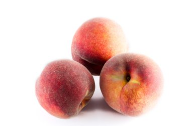 Beyaz arka planda üç olgun şeftali