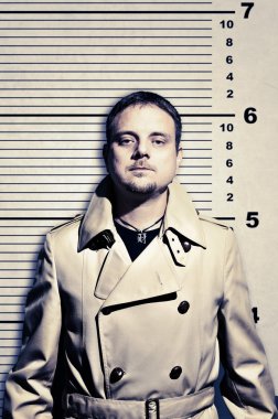 Killer standing on height ruler for photo in prison clipart