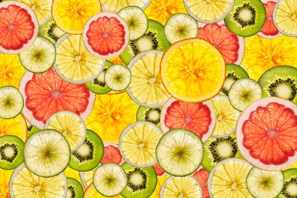 Mélange de fruits tranchés colorés arrière-plan éclairé — Photo