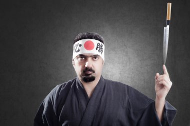 japanese style cook keeps a knife in equilibrium on a finger clipart