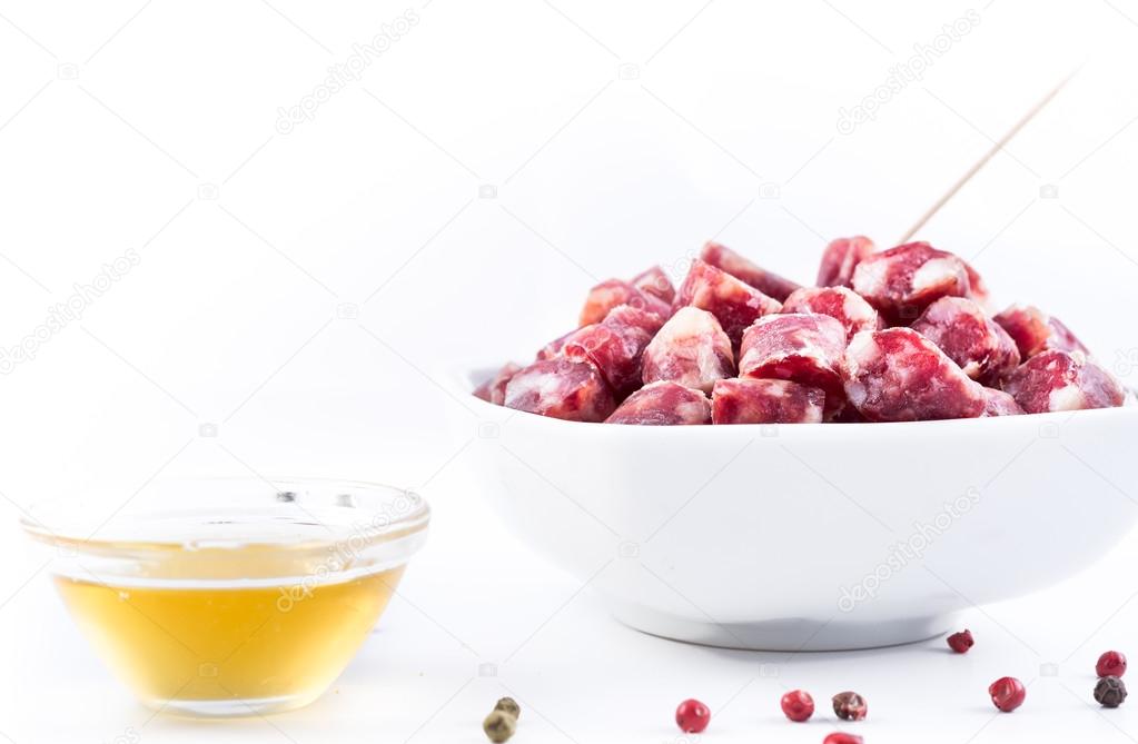 dry sausage cutted in small pieces in a bowl and honey