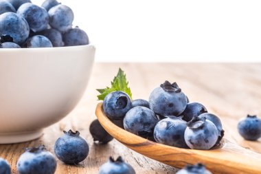 bir ahşap masa ve kase taze yaban mersini