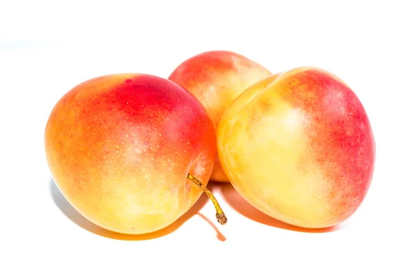 Three orange ripe plums isolated on a white background — Stock Photo, Image