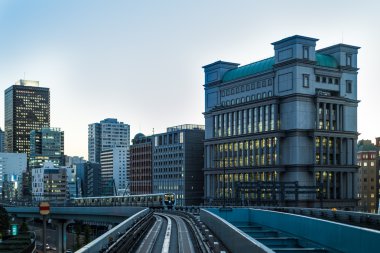 Tokyo Monoray mavi saatte binalar ve tren ile alacakaranlıkta