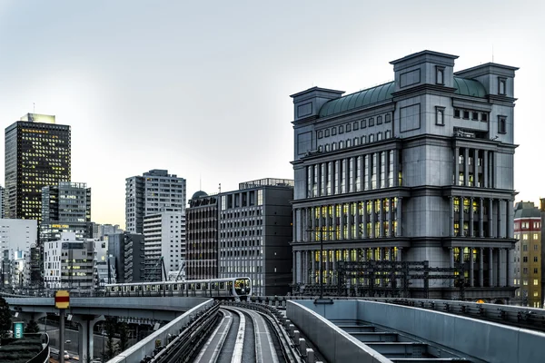 Tokyo monorail in de schemering met gebouwen en trein desaturated — Stockfoto