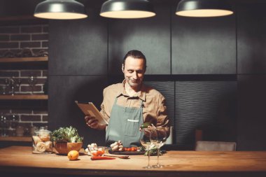 Yetişkin bir adam evinde vejetaryen yemeği hazırlar..