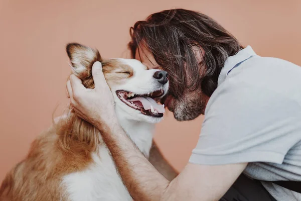 Schöner erwachsener Mann umarmt Hund. — Stockfoto