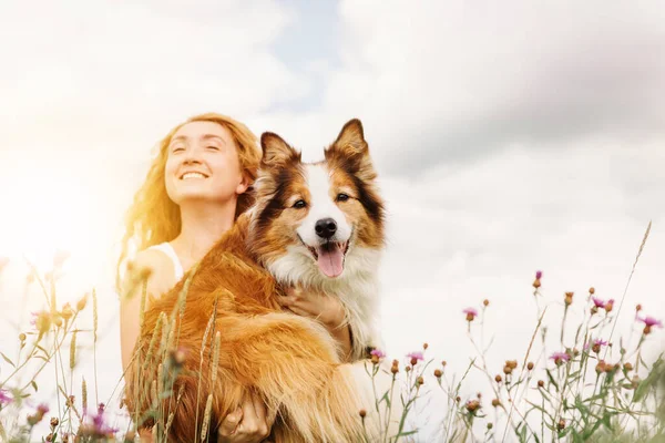 Junge glückliche Frau hält und umarmt ihren Hund. — Stockfoto