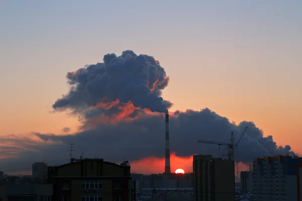 Paisagem urbana ao nascer do sol com cachimbo para fumar — Fotografia de Stock